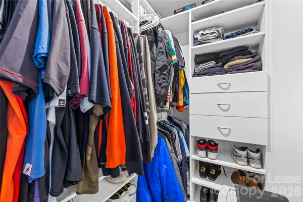 a view of walk in closet with clothes and shoes