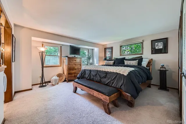 a bedroom with a bed a couch and a window