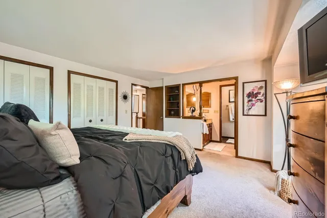 a bedroom with a large bed and a flat tv screen