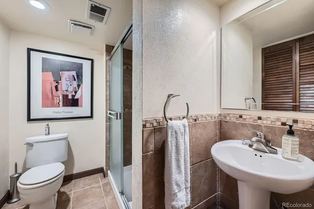 a bathroom with a toilet a sink and mirror