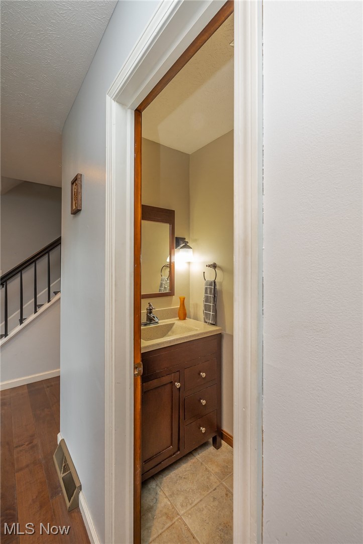7711 Diagonal Road Kent, OH 44240 - Photo 20 of 45 Bathroom featuring vanity, a textured ceiling, and light wood-style flooring