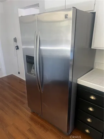 a close view of a refrigerator in kitchen and stainless steel appliances wooden floor