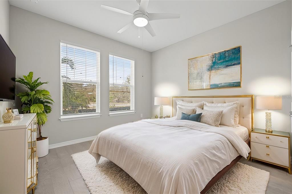 12556 Ryegrass Loop Parrish, FL 34219 - Photo 32 of 49 a bedroom with a large bed and a chandelier