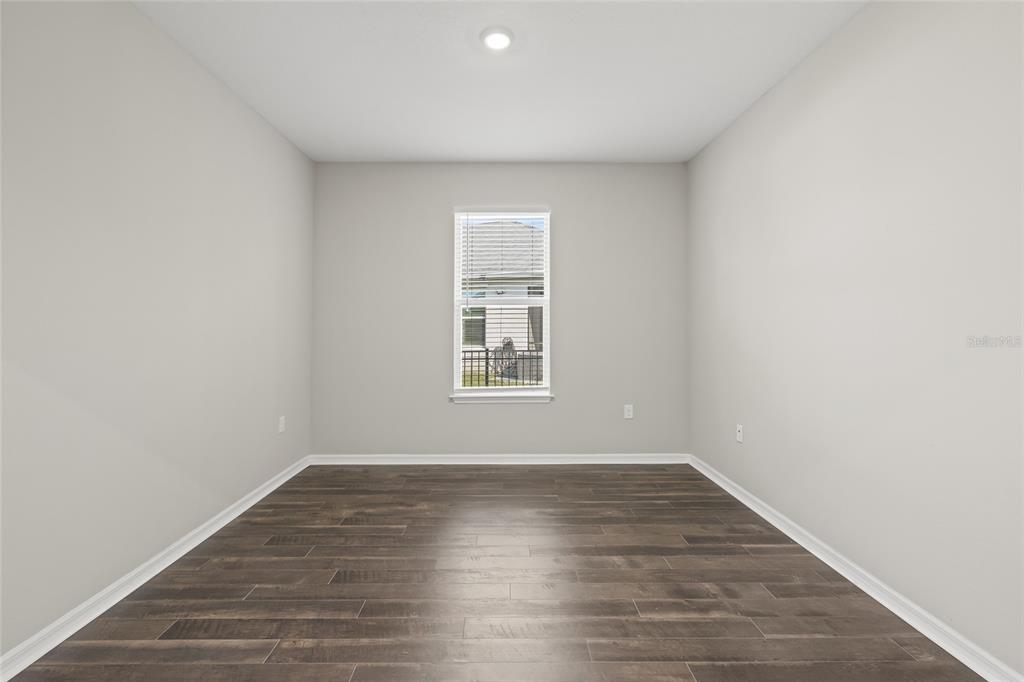 12556 Ryegrass Loop Parrish, FL 34219 - Photo 42 of 49 an empty room with wooden floor and windows