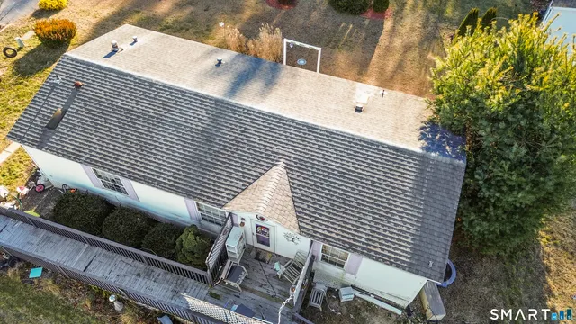 an aerial view of a house with a yard and wooden deck