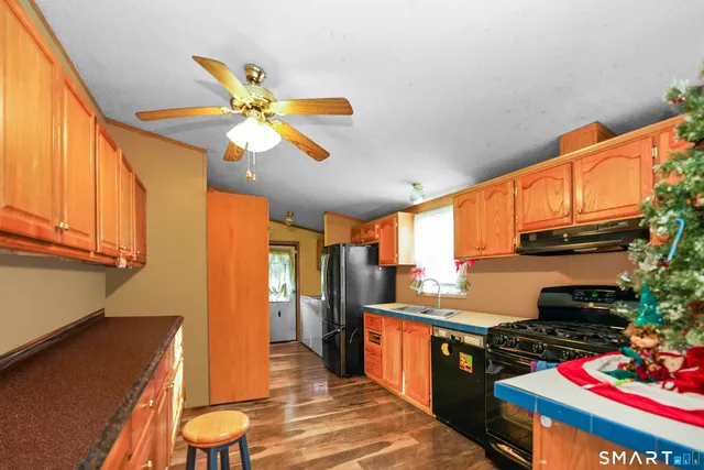 a kitchen with stainless steel appliances granite countertop a sink a stove and a refrigerator