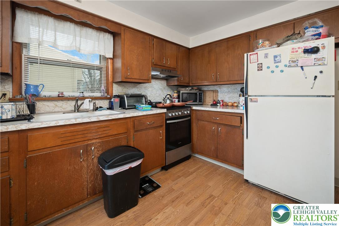 2401 Birch Street Wilson, PA 18042 - Photo 16 of 37 a kitchen with stainless steel appliances granite countertop a refrigerator a sink dishwasher a stove with wooden cabinets