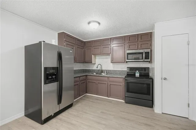 a kitchen with stainless steel appliances granite countertop a refrigerator stove and sink