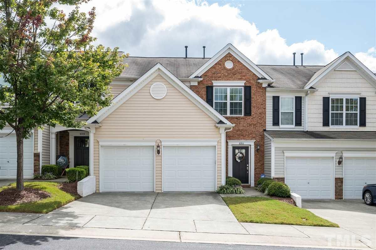 8705 Wild Magnolia Drive Raleigh, NC 27617 - Photo 1 of 15 a view of a brick house with a yard plants and large tree