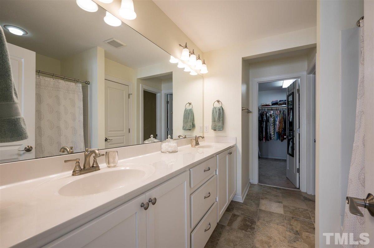 8705 Wild Magnolia Drive Raleigh, NC 27617 - Photo 14 of 15 a bathroom with a double vanity sink and a mirror
