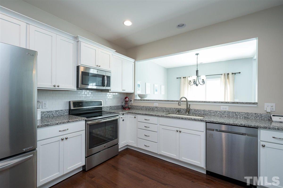 8705 Wild Magnolia Drive Raleigh, NC 27617 - Photo 7 of 15 a kitchen with granite countertop white cabinets white stainless steel appliances and sink