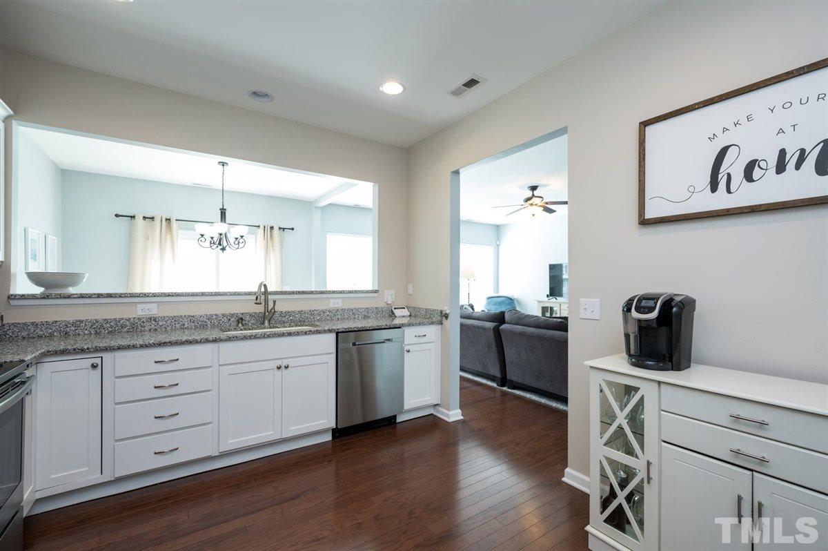 8705 Wild Magnolia Drive Raleigh, NC 27617 - Photo 8 of 15 a kitchen with a sink wooden floor and black appliances