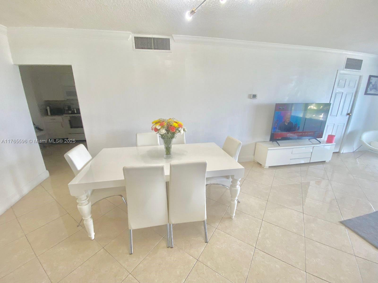 9801 Collins Avenue, Unit 8M Bal Harbour, FL 33154 - Photo 5 of 29 a dining room with furniture and a mirror
