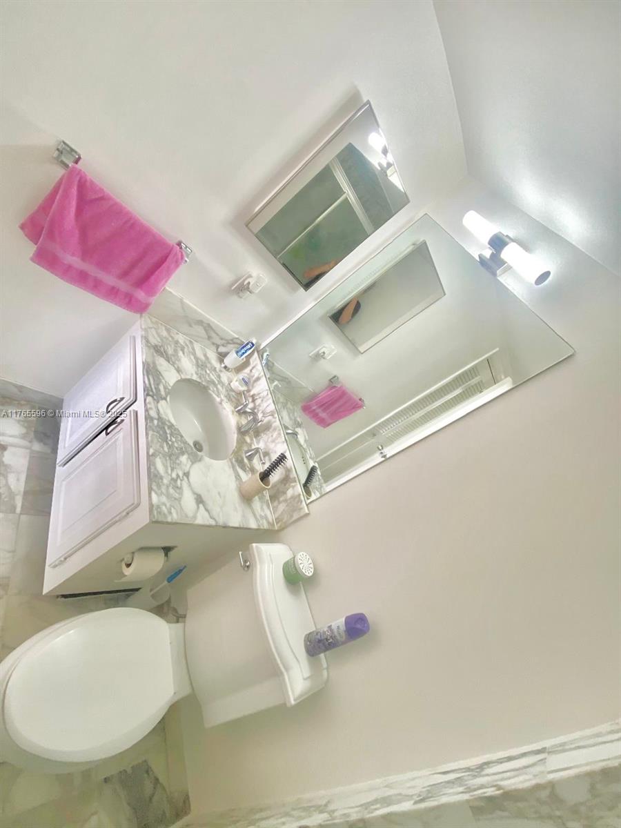 9801 Collins Avenue, Unit 8M Bal Harbour, FL 33154 - Photo 10 of 29 a bathroom with a sink and mirror with bathtub