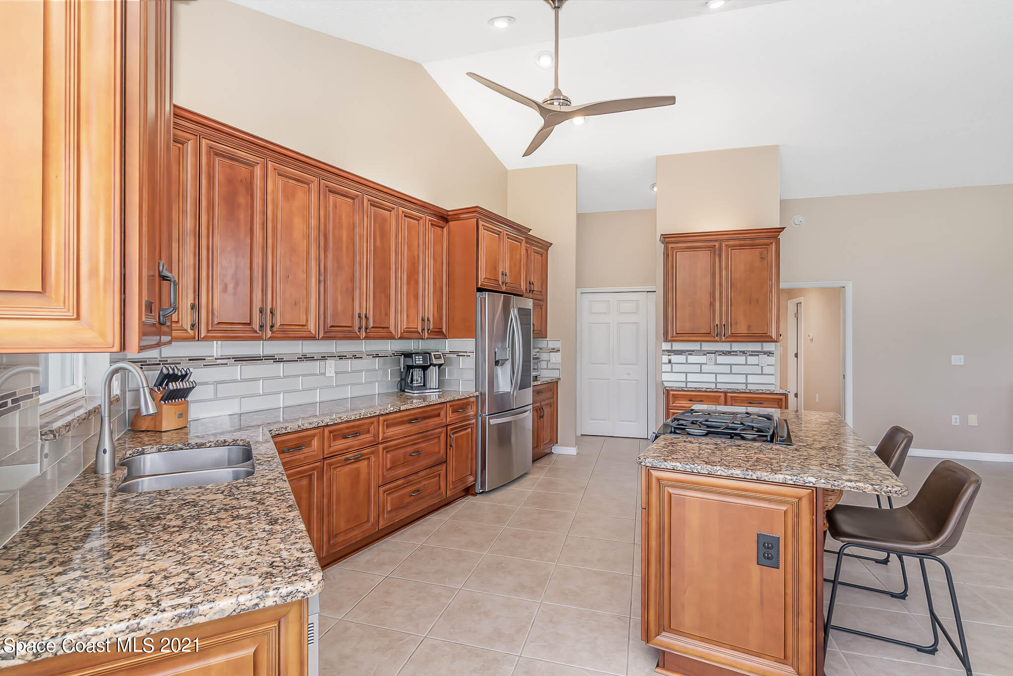 689 Spring Lake Drive Melbourne, FL 32940 - Photo 13 of 49 a kitchen with stainless steel appliances granite countertop a stove a sink and a refrigerator