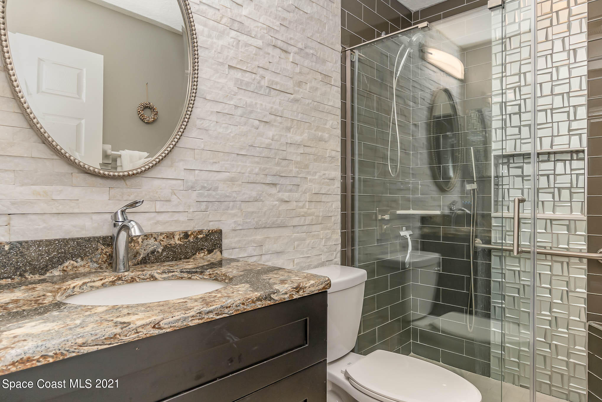 689 Spring Lake Drive Melbourne, FL 32940 - Photo 25 of 49 a bathroom with a granite countertop sink toilet and shower
