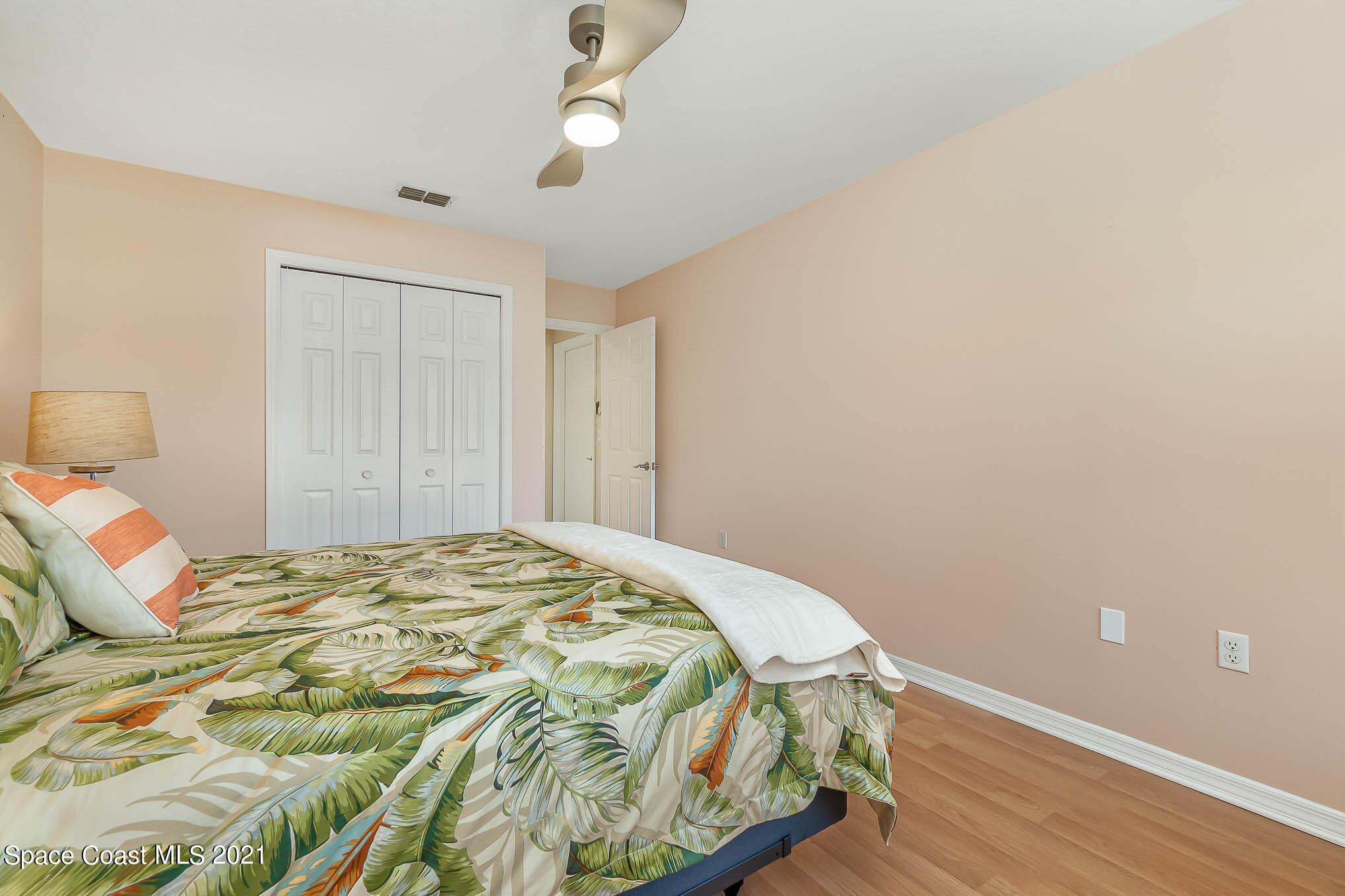 689 Spring Lake Drive Melbourne, FL 32940 - Photo 26 of 49 a bedroom with a bed and a lamp