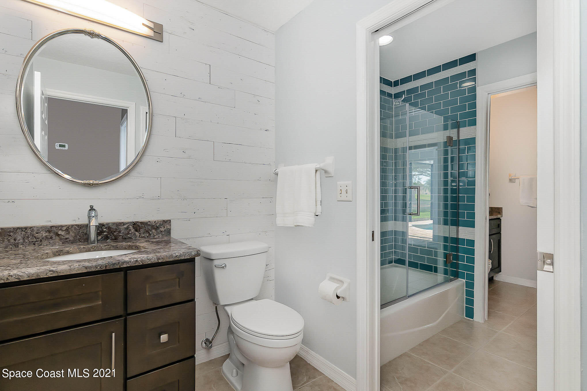 689 Spring Lake Drive Melbourne, FL 32940 - Photo 30 of 49 a bathroom with a sink a toilet and a mirror