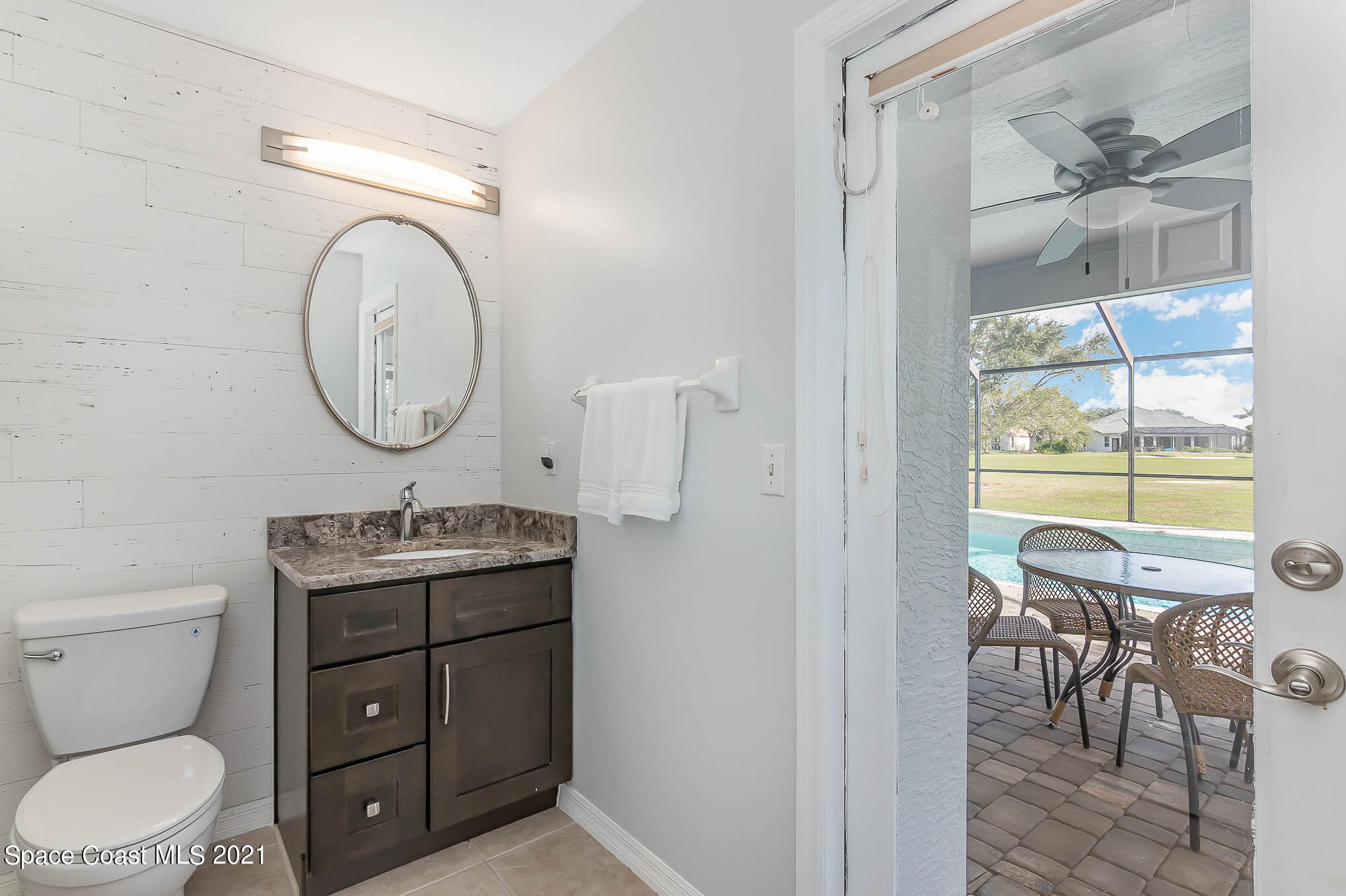 689 Spring Lake Drive Melbourne, FL 32940 - Photo 31 of 49 a bathroom with a toilet a sink and a mirror