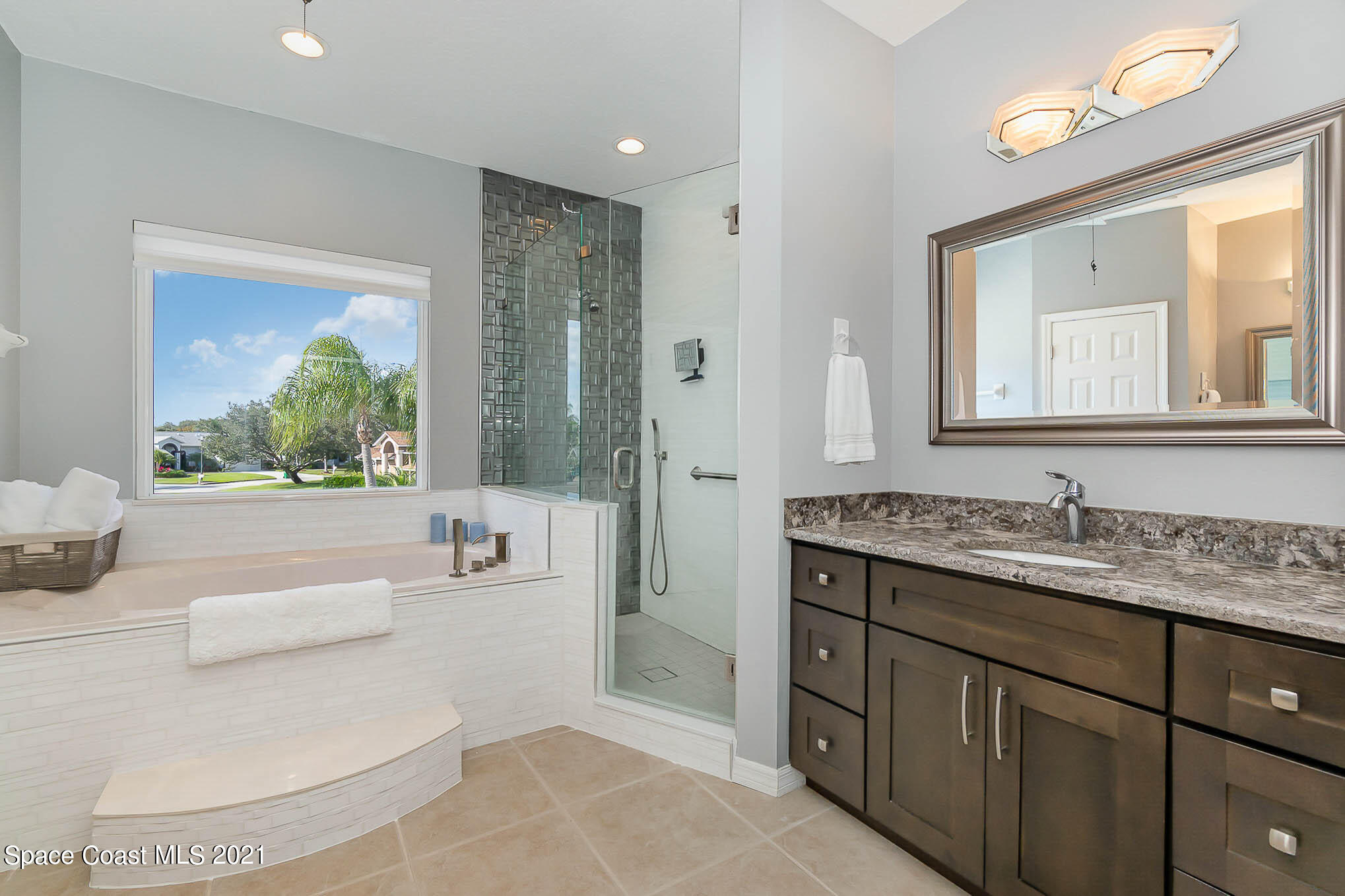 689 Spring Lake Drive Melbourne, FL 32940 - Photo 41 of 49 a spacious bathroom with a double vanity sink a mirror and a shower