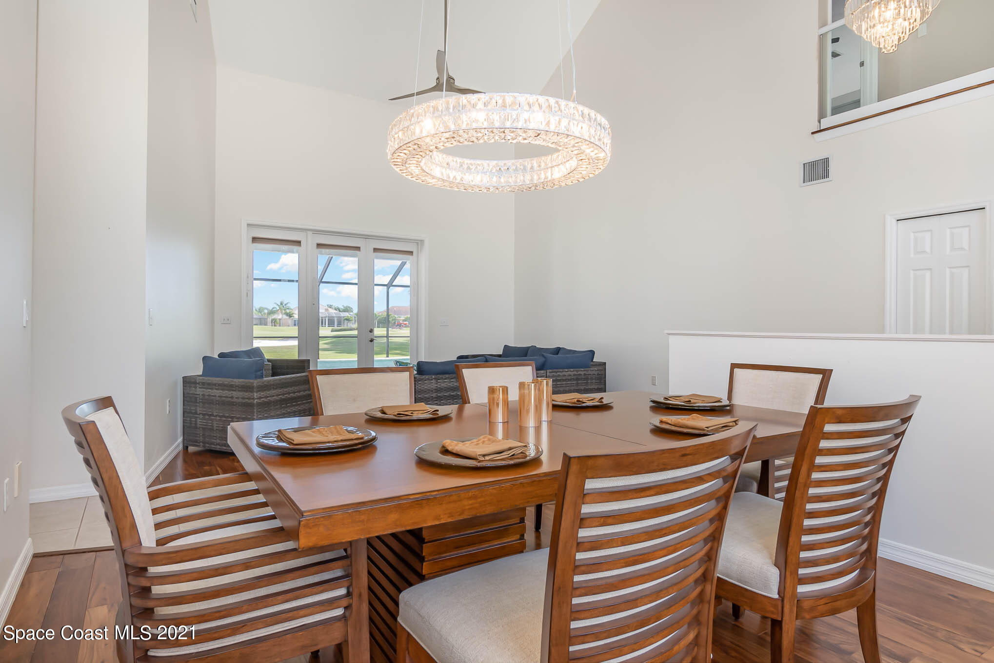 689 Spring Lake Drive Melbourne, FL 32940 - Photo 7 of 49 a view of a dining room with furniture a chandelier and wooden floor