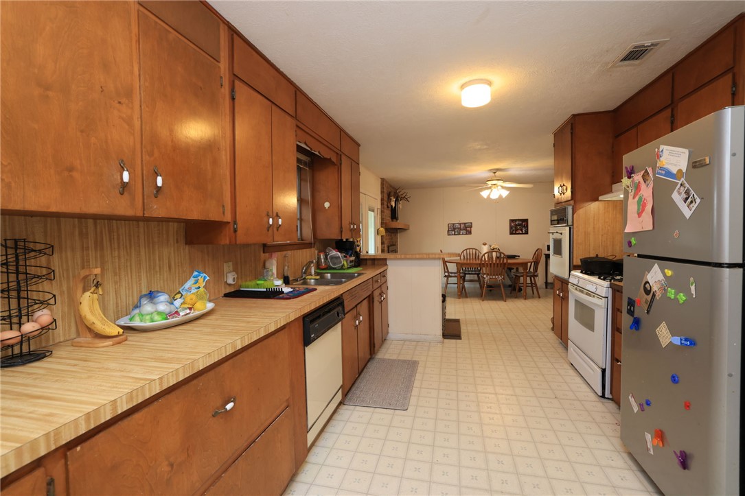 7474 Welch Road Bryan, TX 77808 - Photo 11 of 27 a large kitchen with stainless steel appliances kitchen island granite countertop a sink and cabinets