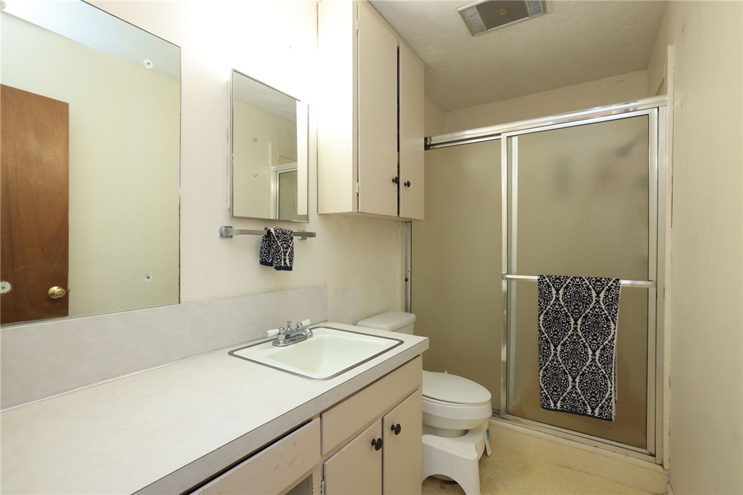 7474 Welch Road Bryan, TX 77808 - Photo 15 of 27 a bathroom with a granite countertop sink toilet and shower