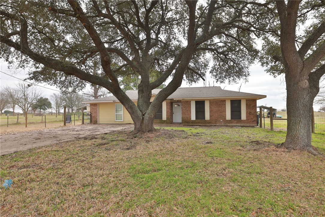 7474 Welch Road Bryan, TX 77808 - Photo 2 of 27 a front view of a house with a garden