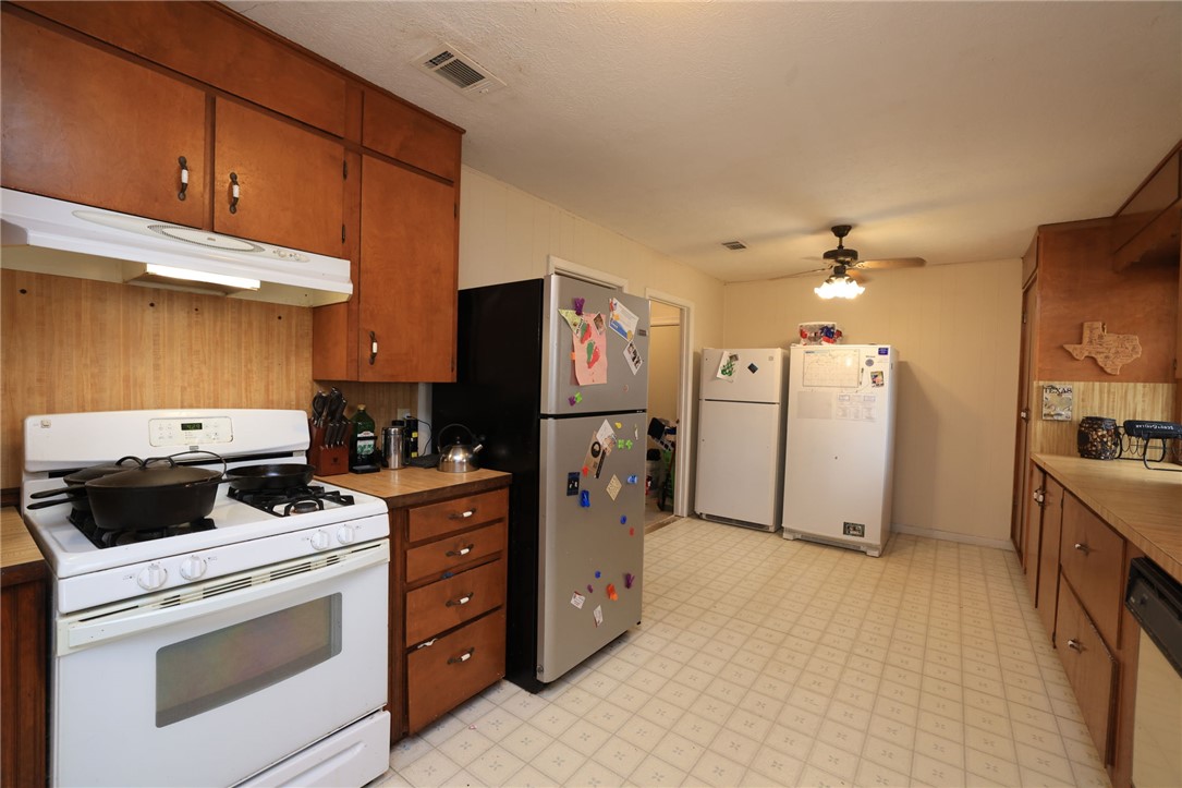 7474 Welch Road Bryan, TX 77808 - Photo 10 of 27 a kitchen with stainless steel appliances a stove a refrigerator and cabinets