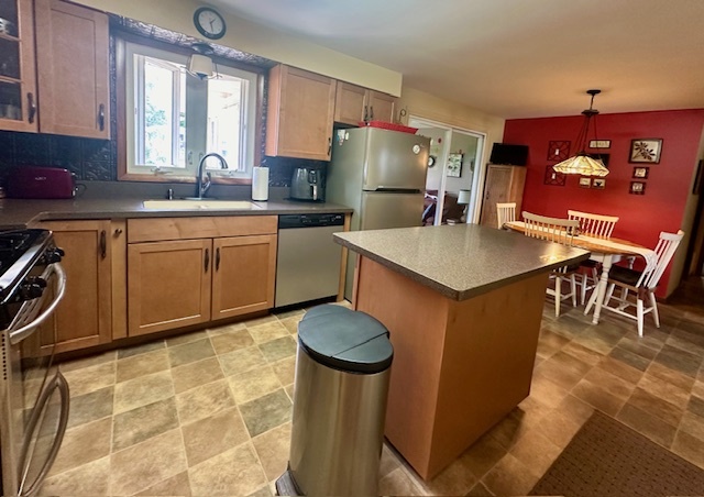 1364 West Tower Road Kankakee, IL 60901 - Photo 8 of 18 a kitchen with stainless steel appliances granite countertop a table chairs a refrigerator and cabinets