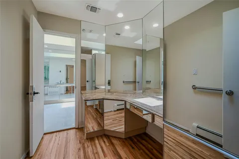 a bathroom with a granite countertop sink mirror and a bathtub