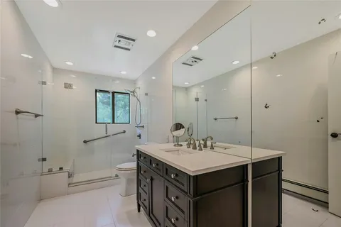 a bathroom with a sink double vanity granite tub and a mirror