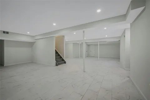an empty room with white wall and staircase