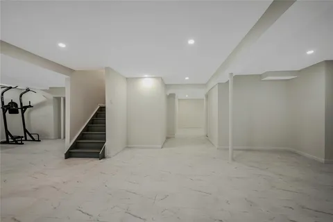 an empty room with staircase and white walls