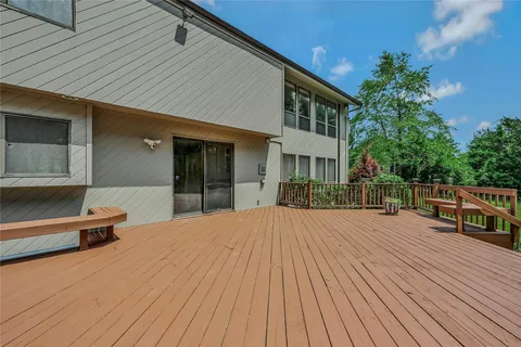 a balcony with wooden floor table and chairs