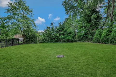 a view of a green field with wooden fence