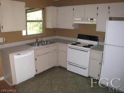 17440 Kentucky Road Fort Myers, FL 33967 - Photo 3 of 6 a kitchen with cabinets appliances a sink and a window