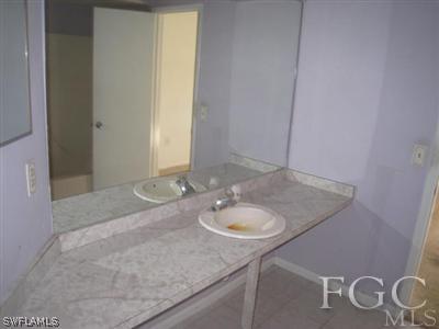 17440 Kentucky Road Fort Myers, FL 33967 - Photo 4 of 6 a bathroom with a granite countertop sink and a mirror