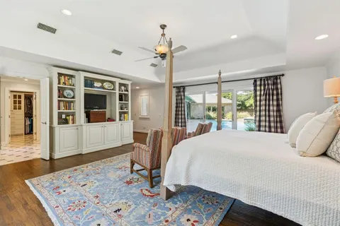 a living room with furniture large window and wooden floor