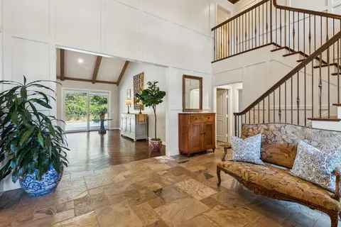 a dining room with furniture a chandelier and wooden floor