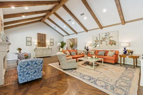 a living room with furniture a fireplace and a floor to ceiling window