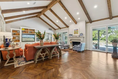 a living room with furniture fireplace and a large window