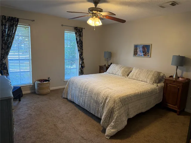 a spacious bedroom with a bed and a chandelier