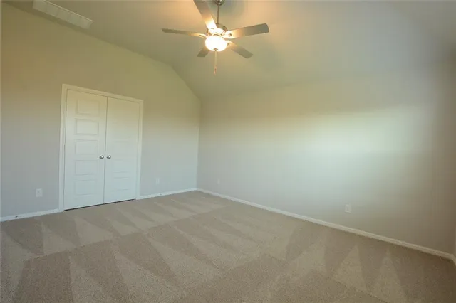 an empty room with a fan & a window