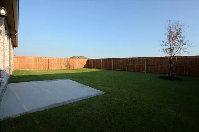 a view of yard with swimming pool and wooden fence