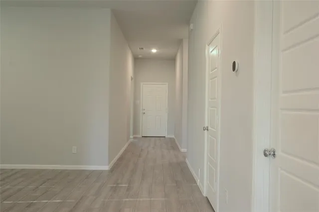 a view of a hallway with wooden floor