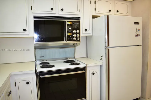 a kitchen with refrigerator a stove a microwave and cabinets