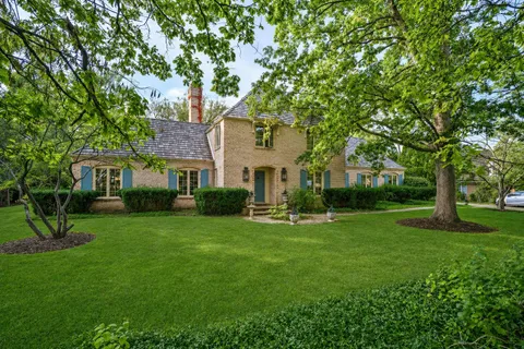 a front view of a house with a yard and trees
