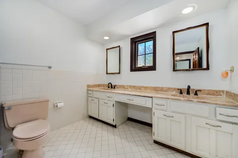 a bathroom with a toilet sink and mirror