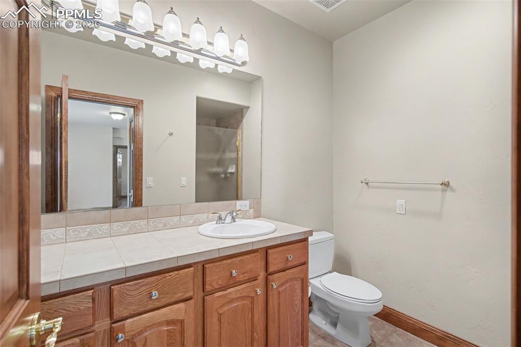4215 Star Ranch Road Colorado Springs, CO 80906 - Photo 40 of 44 a bathroom with a sink a toilet and a mirror